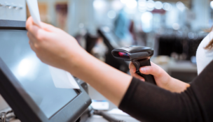 hand holding receipt to scan barcode at register